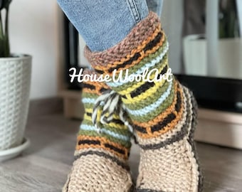 May include: Hand-knitted wool slippers with a striped pattern in shades of beige, brown, orange, green, and blue. The slippers have a textured appearance and a cuff at the top. The text "House Wool Art" is visible on the slippers.