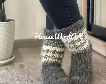 May include: Gray and white knit wool boot socks. The socks have a striped pattern in the middle and are labeled "HouseWoolArt". The socks are thick and appear warm.