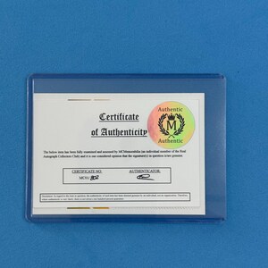Peut inclure: Un certificat d'authenticit&eacute; dans une pochette en plastique transparent. Le certificat porte le texte "Certificate of Authenticity" et un sceau "Authentic". Le num&eacute;ro de certificat est MC01/802.