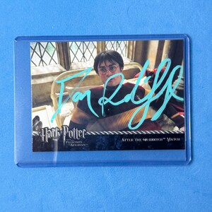 Puede incluir: Una tarjeta coleccionable con una escena de Harry Potter y el prisionero de Azkaban, que muestra a un personaje con un suéter de rayas, una firma en azul brillante en el frente y el texto After the Quidditch Match en la parte inferior.