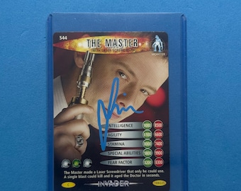 May include: A trading card of "The Master" with a laser screwdriver, signed in blue ink. The card features a monster graphic and includes statistics for intelligence, agility, stamina, special abilities, and fear factor. The card is in a protective sleeve.