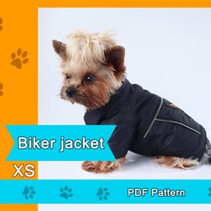 May include: A small dog wearing a black biker jacket with a zipper detail. The jacket is labeled "XS" and the image includes the text "Biker jacket" and "PDF Pattern". The dog has light brown and dark brown fur.