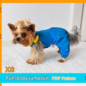 May include: A small dog wearing a blue full-body jumpsuit with a yellow collar accent. The text XS and Full-body jumpsuit PDF Pattern are visible on the image. The garment covers the torso and legs of the dog, featuring a solid blue fabric.