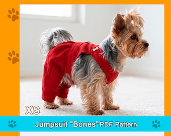 May include: A small dog wearing a red jumpsuit with a bone-shaped button. The jumpsuit covers the dog's legs and torso. The text "XS" is in the lower left corner, and "Jumpsuit "Bones" PDF Pattern" is below the dog.