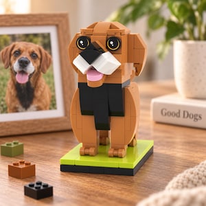 Op de afbeelding: Een bruin en beige hondenfiguur opgebouwd uit in elkaar grijpende plastic bouwstenen. Het figuur heeft een zwarte borst, witte snuit, roze tong en grote donkere ogen, staand op een rechthoekige limoengroene basis met drie losse blokjes.