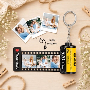 Puede incluir: Un llavero de cartucho de película de 35mm en negro y amarillo con una tira de fotos extraíble. La tira presenta un icono de corazón rojo, el texto Your text y una serie de fotos impresas. El cartucho está etiquetado 35mm color print film.