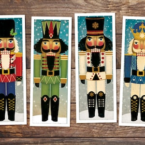 Puede incluir: Cuatro figuritas de cascanueces ilustradas con uniformes y sombreros de diferentes colores. Los cascanueces están de pie frente a un fondo azul con copos de nieve blancos.
