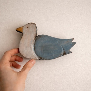 May include: A white ceramic mug with a black handle and the text "But First, Coffee" in a black, handwritten-style font. The mug is on a white surface.