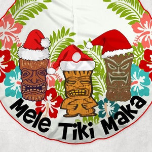 May include: A white Christmas tree skirt with a tropical theme. It features three tiki figures wearing Santa hats and the text "Mele Tiki Maka".