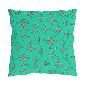 May include: A turquoise throw pillow with a repeating pattern of brown geometric shapes.