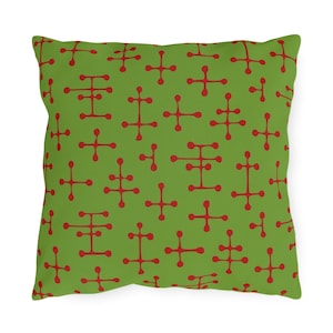 May include: Green throw pillow with a red geometric pattern. The pattern is a repeating design of four-pointed stars.