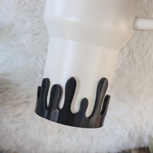 May include: White ceramic tumbler with a black drip design around the bottom edge.