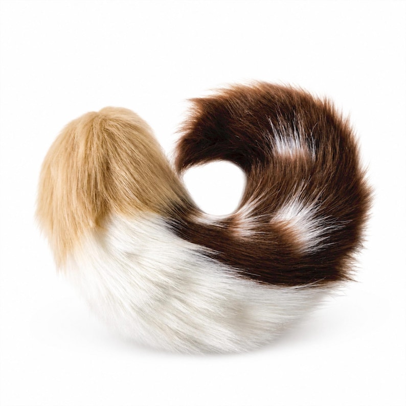 May include: A plush, curved animal tail accessory made of faux fur. The texture is long and soft, featuring a color gradient that transitions from a light tan at the base to a bright white middle section, ending in a deep dark brown tip.