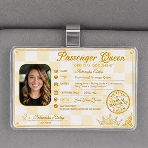 May include: A rectangular plastic visor clip featuring a cream and white checkered background. The text reads Passenger Queen, Official Document, Name Antonesha Staley, Title Professional Passenger Queen, Duties, Certified Since 05/10/1992, and Status Full-Time Queen.