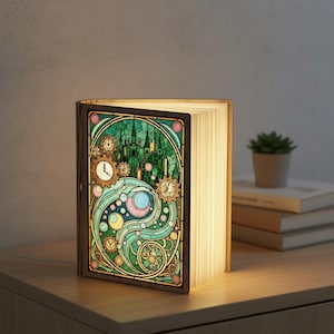May include: A wooden book-shaped lamp with a stained-glass design. The design features a green castle, gears, and swirling patterns in shades of green, blue, and pink. The pages of the book are illuminated, creating a warm glow.