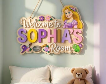 Può includere: Cartello in legno con la scritta "Welcome to SOPHIA'S Room" con un'illustrazione di principessa, fiori e una rana. Il cartello è in colori pastello e appeso a una corda.