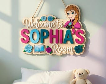 Può includere: Un cartello in legno con la scritta "Welcome to SOPHIA'S Room" in bianco, rosa e turchese. Il cartello presenta un'immagine a cartoni animati di una ragazza con una treccia e dettagli floreali. Appeso con una corda di iuta.