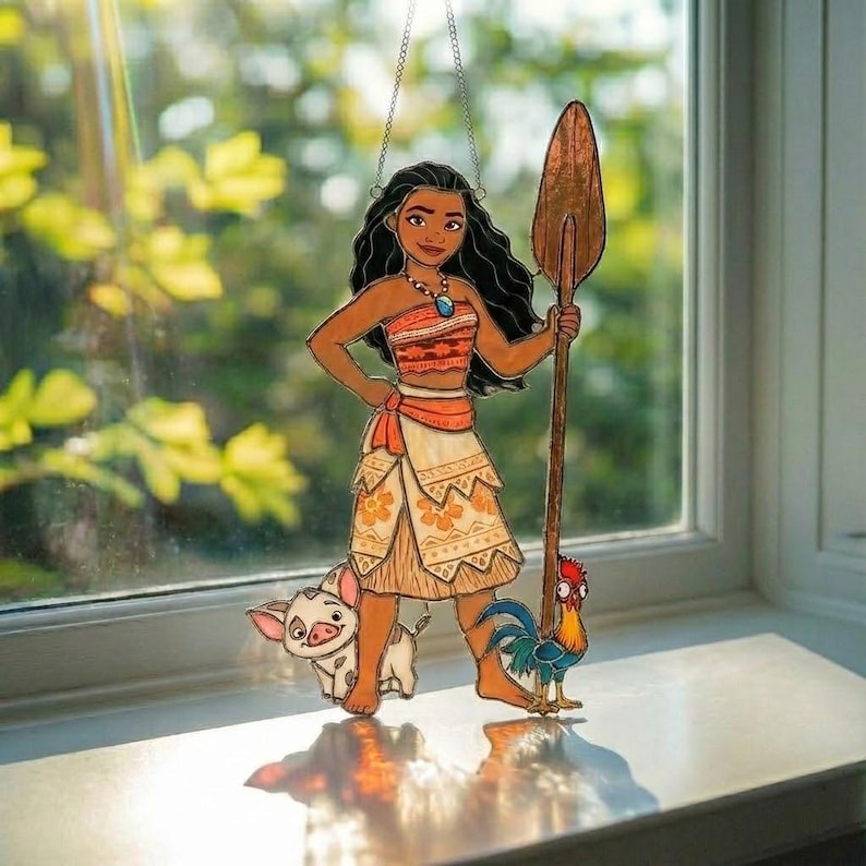 K&ouml;nnte beinhalten: Ein Buntglas-Suncatcher zeigt eine Figur mit langem schwarzem Haar, die ein gemustertes orange-cremefarbenes Outfit mit einer blauen Halskette tr&auml;gt. Die Figur h&auml;lt ein langes h&ouml;lzernes Ruder, begleitet von einem kleinen Schwein und einem bunten Hahn.