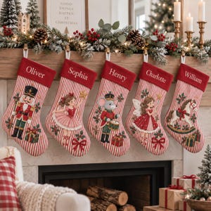 以下が含まれることがあります： 赤と白のストライプ柄で赤いカフが付いた5つのクリスマスストッキング。各カフにはOliver、Sophia、Henry、Charlotte、Williamという名前が刺繍されています。ストッキングには、くるみ割り人形、バレリーナ、ネズミ、妖精、木馬のイラストが描かれています。