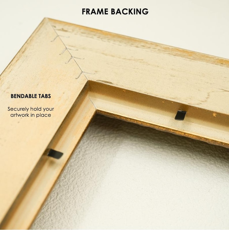 May include: Close-up of a corner of a beige picture frame. The frame has a distressed finish and features the text "FRAME BACKING" and "BENDABLE TABS" with the phrase "Securely hold your artwork in place".