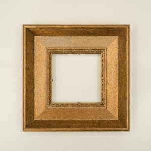 Könnte beinhalten: Ein quadratischer, goldfarbener Bilderrahmen mit einem mehrschichtigen Design. Der Rahmen hat einen detaillierten Innenrand und eine strukturierte Oberfläche, geeignet für die Präsentation von Fotos oder Kunstwerken. Die Abmessungen betragen ca. 25 cm x 25 cm.