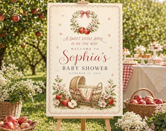 Puede incluir: Un cartel de bienvenida rectangular para baby shower con borde rojo festoneado, que presenta una corona de manzanas y flores, una ilustración de un moisés de mimbre y el texto: A Sweet Little Apple Is On The Way Welcome To Sophia's Baby Shower October 11, 2026.