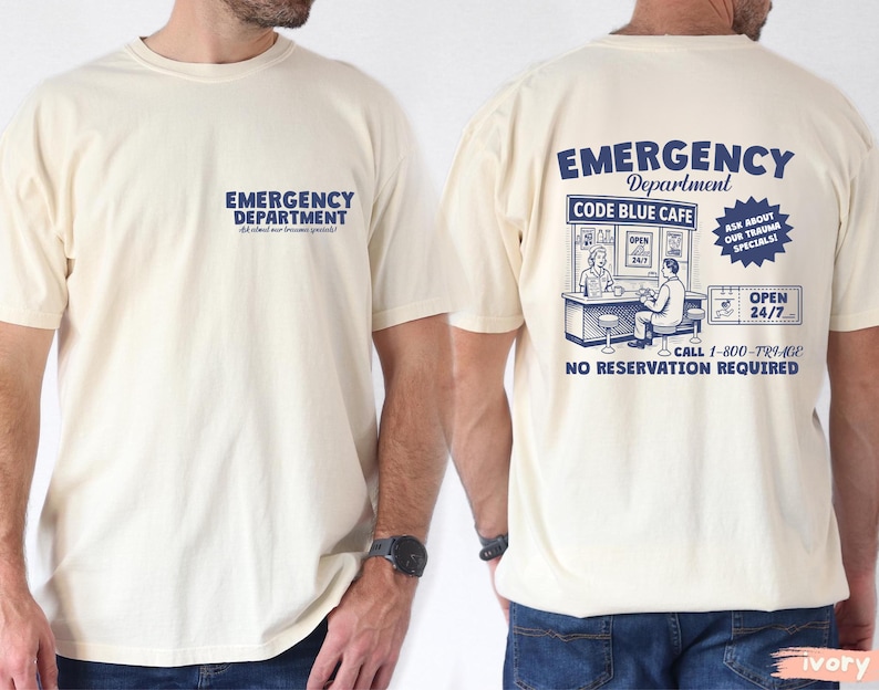 May include: Cream-colored t-shirt with the words "EMERGENCY DEPARTMENT" printed in blue on the front and back. The back of the shirt features a graphic of a cafe with the text "CODE BLUE CAFE" and "OPEN 24/7".