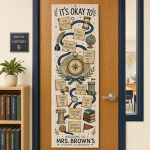 May include: A vertical fabric banner hanging on a door, featuring the text IT'S OKAY TO and MRS. BROWN'S HISTORY CLASSROOM. It displays illustrations of a compass, globe, hourglass, books, and parchment scrolls with educational phrases.