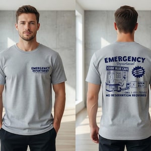 May include: A light gray t-shirt with the words "EMERGENCY DEPARTMENT" printed in navy blue on the front. The back of the shirt features a navy blue graphic with the words "EMERGENCY DEPARTMENT" and "CODE BLUE CAFE".