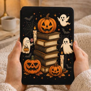 Może przedstawiać: Czarne etui na tablet z ilustracją o tematyce Halloween, przedstawiającą stos książek, trzy dynie, dwa duszki, dwie zapalone świece, pajęczyny, nietoperze i małe pomarańczowe gwiazdki. Jeden duszek trzyma lizaka i małe wiaderko w kształcie dyni.