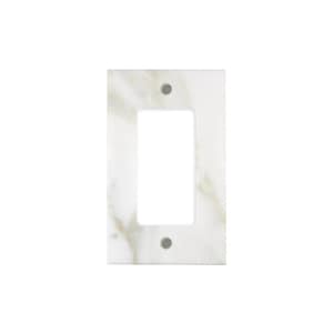 May include: A rectangular light switch plate with a single opening. The plate has a marble-like pattern with white and beige tones. Two small, gray screws are visible near the top and bottom of the opening.