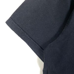 K&ouml;nnte beinhalten: Nahaufnahme des dunkelblauen Stoffes eines T-Shirt-&Auml;rmels. Der Stoff ist glatt und hat eine subtile Textur.