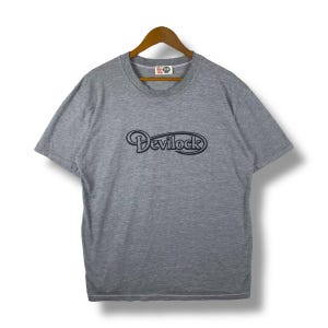 Puede incluir: Una camiseta de manga corta gris jaspeada con un logotipo bordado en negro que dice "Deviluck".