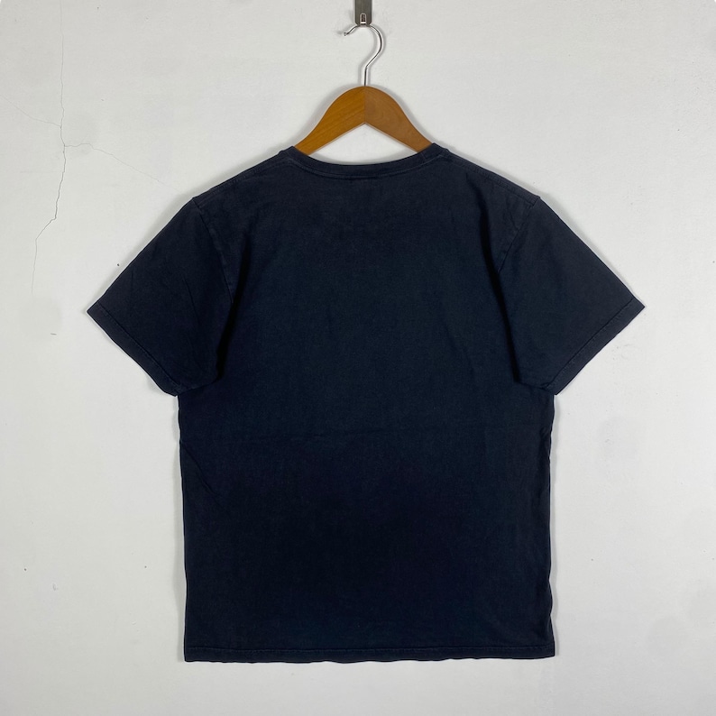 K&ouml;nnte beinhalten: Ein schwarzes T-Shirt mit kurzen &Auml;rmeln und Rundhalsausschnitt.