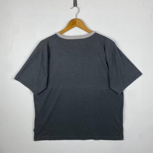 K&ouml;nnte beinhalten: Ein dunkelgraues T-Shirt mit kurzen &Auml;rmeln und einem hellgrauen Saum am Ausschnitt.