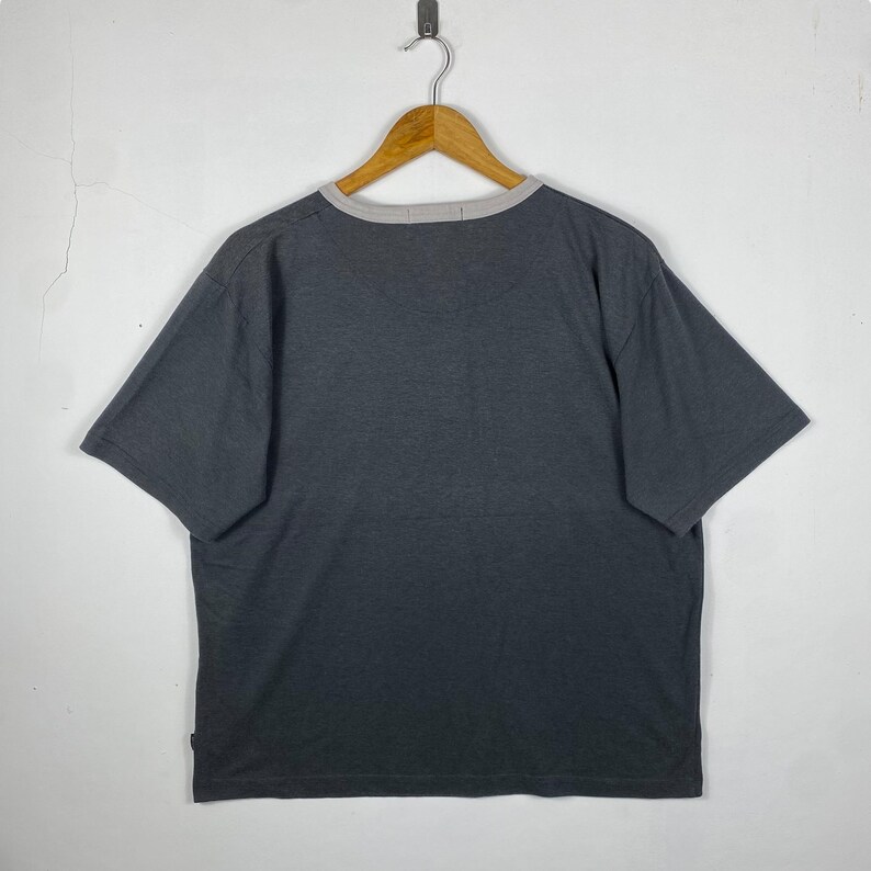 K&ouml;nnte beinhalten: Ein dunkelgraues T-Shirt mit kurzen &Auml;rmeln und einem hellgrauen Saum am Ausschnitt.