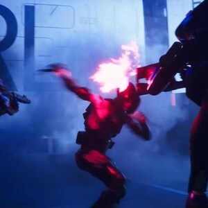 Puede incluir: Una escena de acci&oacute;n dram&aacute;tica con tres figuras con armaduras futuristas, iluminadas por luces rojas y azules. Una figura est&aacute; envuelta en llamas, mientras que otras sostienen armas, lo que sugiere un tema de ciencia ficci&oacute;n o acci&oacute;n.