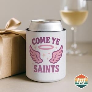 Puede incluir: Enfriador de latas blanco con el texto "COME YE SAINTS" en morado, junto con alas de ángel rosas y un halo. Una lata plateada se encuentra dentro del enfriador. Una caja de regalo con un lazo dorado está en el fondo.