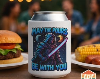 May include: White can cooler with the text "MAY THE POURS BE WITH YOU" and a graphic of a hooded figure holding a lightsaber. The design features a space theme with moons and stars. The cooler is on a wooden table.