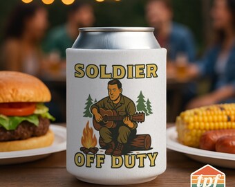 May include: A white can cooler with the words "SOLDIER OFF DUTY" and an illustration of a person playing a guitar by a campfire. The cooler is on a wooden table with a burger, corn, and sausages in the background.