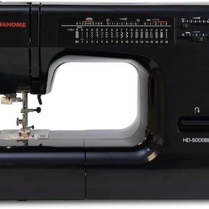 May include: A black Janome HD-5000BE sewing machine. The machine has a variety of stitch options displayed on a panel, with dials and controls on the right side. The Janome logo is in red.