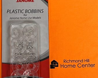 May include: A package of clear plastic bobbins for Janome Home Use Models. The package is red and white with the brand name "JANOME" at the top. The text "PLASTIC BOBBINS" is printed on the package.