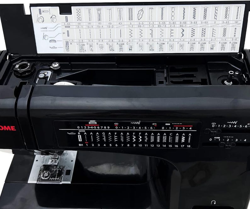 May include: A black sewing machine with a hinged top revealing stitch options. The machine has a control panel with numbered settings and stitch patterns. The brand name is visible in red. The machine is on a white surface.