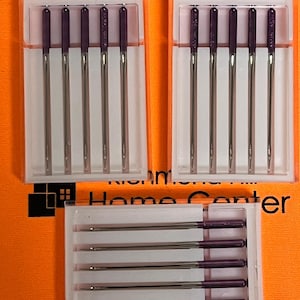 May include: Three clear plastic containers with rows of purple-tipped sewing machine needles. The containers are labeled "Richmond Home Center".
