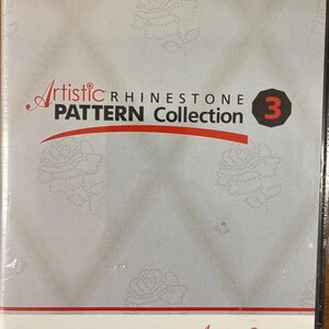 Puede incluir: Una caja de DVD con el texto "Artistic Rhinestone Pattern Collection 3". La cubierta es de color gris claro con un patrón de rosas y el logotipo de Artistic. La parte inferior de la caja tiene la dirección del sitio web www.ArtisticCreativeProducts.com.