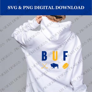 May include: White hoodie with the letters "BUF" in blue and yellow, a hockey stick and puck in blue, and a blue buffalo silhouette.