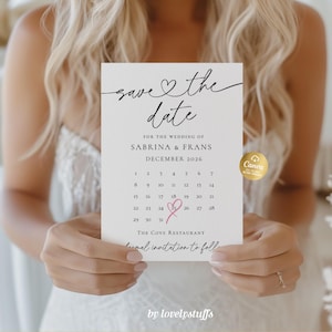 May include: A white wedding invitation card with the text "save the date" in elegant script. The card includes a calendar for December 2026, the names Sabrina & Frans, and the venue, The Cove Restaurant. A pink heart highlights the date.