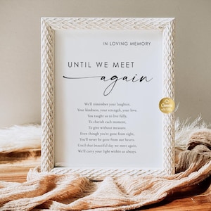 May include: A framed memorial sign with the text "IN LOVING MEMORY" and "UNTIL WE MEET again". The white frame has a textured, carved design. The sign includes a poem about remembrance and love. A Canva logo is visible.