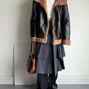b3 bomber jacket women, brown sheepskin coat, distressed leather bomber, vintage flight trench, real lambskin outerwear, sheepskin aviator jacket, winter fur collar coat, cozy shearling bomber, classic raf style coat, pilot bomber women, 1940s flight jacket, fur lined bomber coat, leather trench coat winter, warm bomber jacket ladies, retro shearling outerwear, sheepskin leather bomber, heavy lambskin jacket, stylish winter flight coat, women's aviator trench, handmade leather bomber