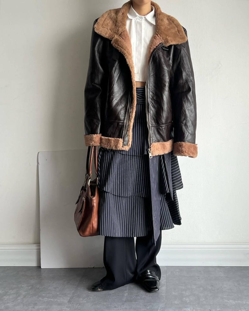 b3 bomber jacket women, brown sheepskin coat, distressed leather bomber, vintage flight trench, real lambskin outerwear, sheepskin aviator jacket, winter fur collar coat, cozy shearling bomber, classic raf style coat, pilot bomber women, 1940s flight jacket, fur lined bomber coat, leather trench coat winter, warm bomber jacket ladies, retro shearling outerwear, sheepskin leather bomber, heavy lambskin jacket, stylish winter flight coat, women's aviator trench, handmade leather bomber